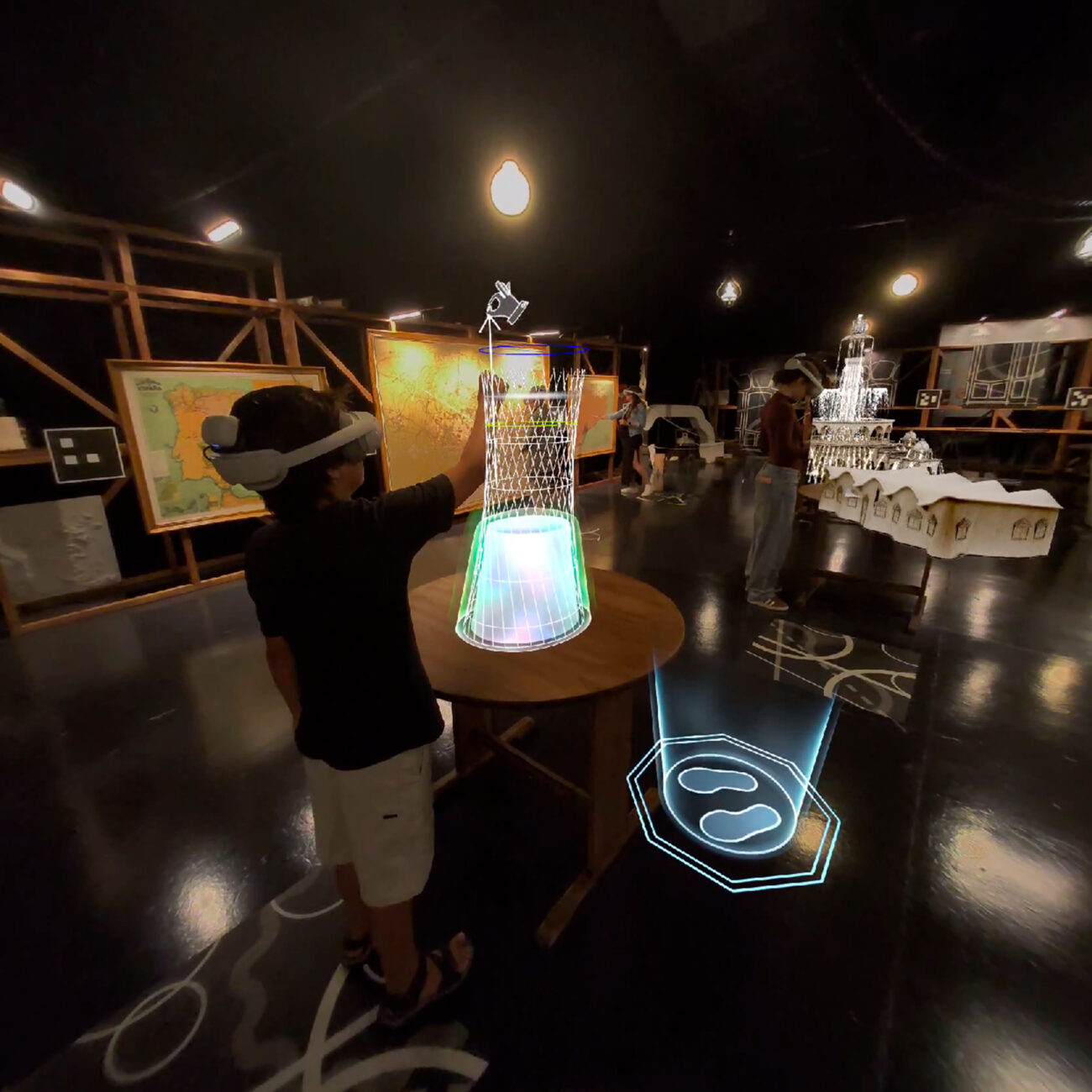 Un nen amb ulleres de realitat virtual interactuant amb una taula tàctil il·luminada a l'exposició Codi Gaudí